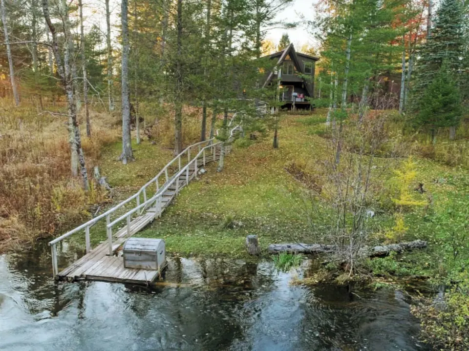 Serenity A-Frame and its riverside deck, seen across the Betsie River